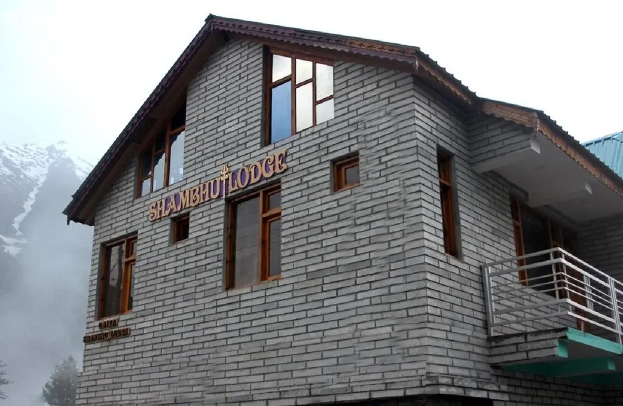 The Shambhu Lodge, a stone-and-timber lodge in Rakchham under mountain cloud